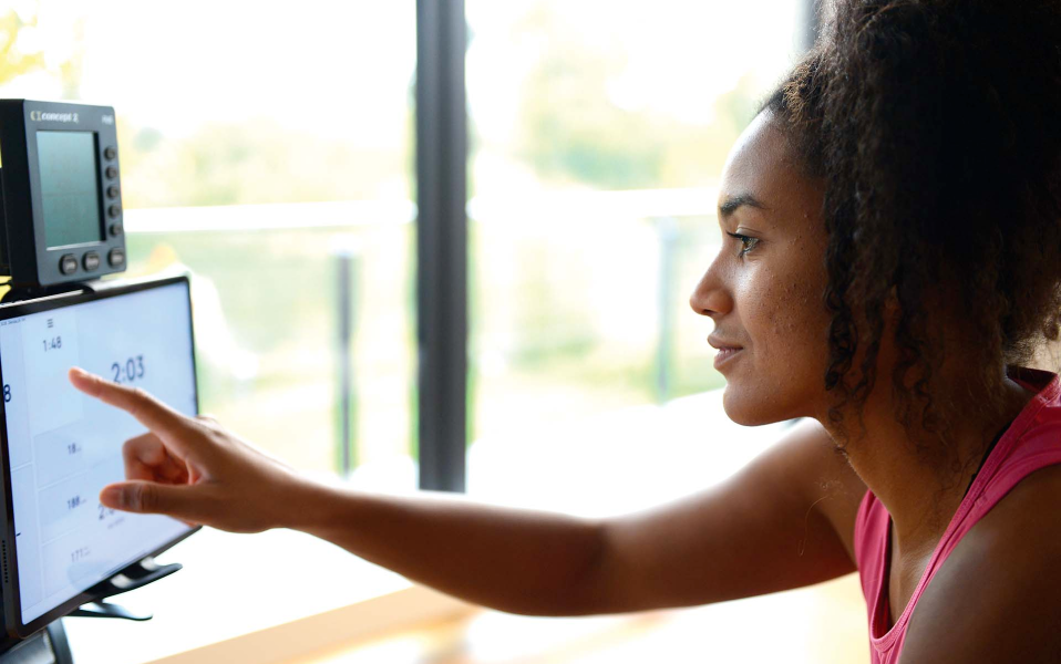 Woman interacting with a computer screen displaying a software interface.