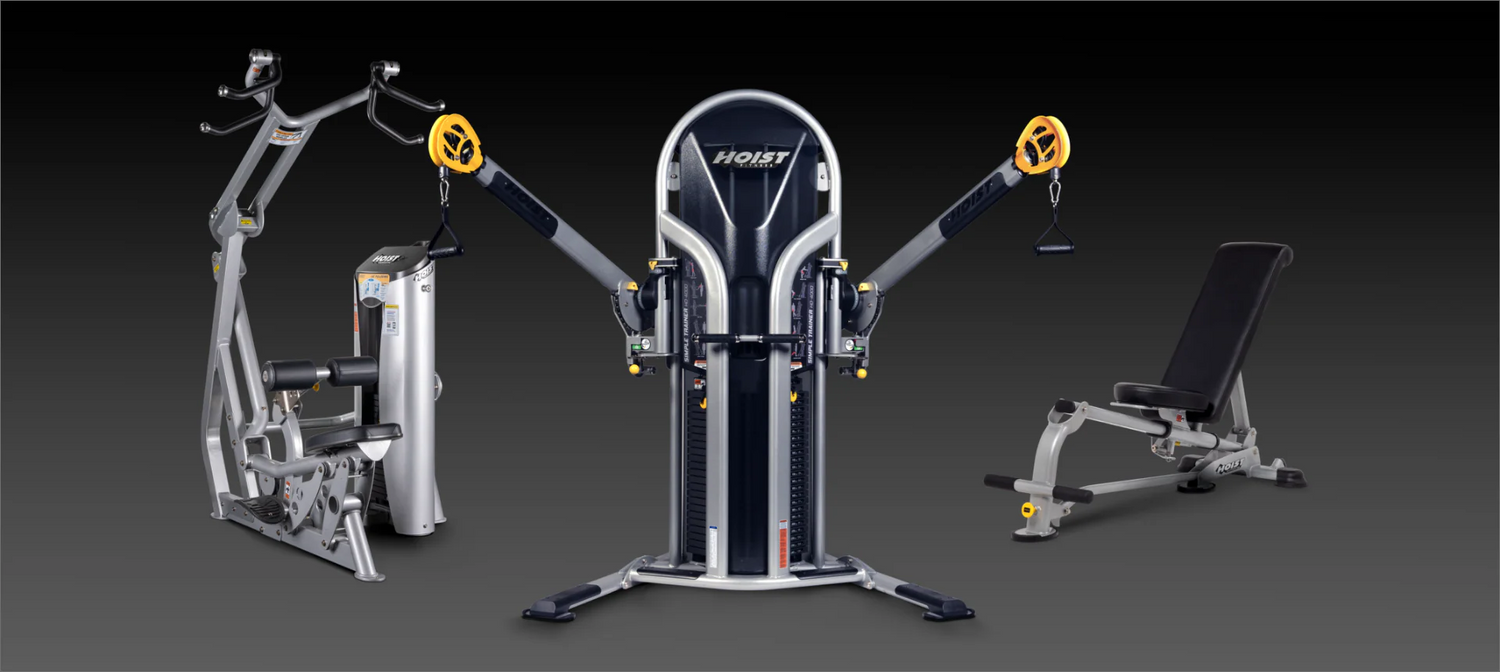 Set of gym equipment including a lat pulldown machine, weight bench, and cable machine on a dark background.