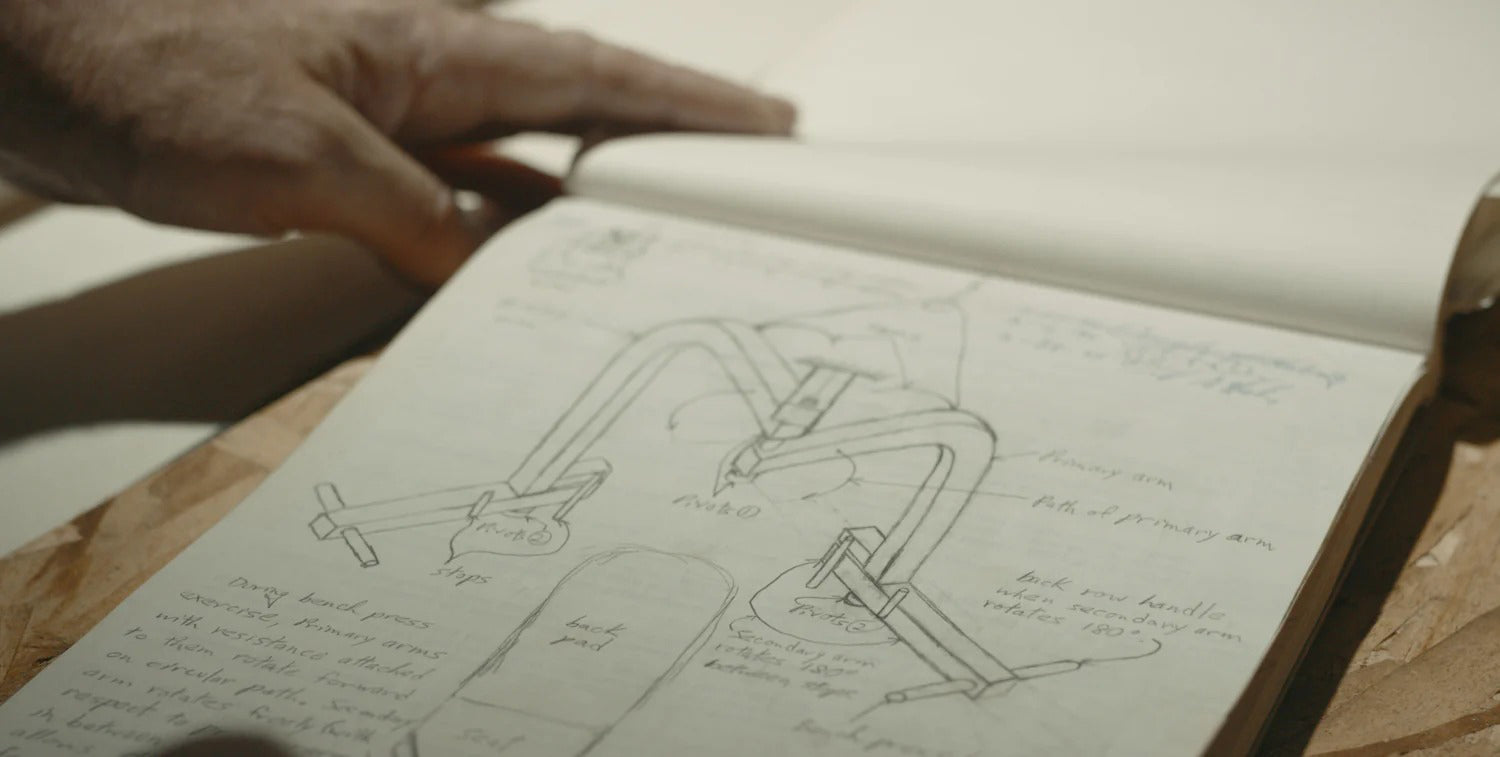 Open notebook with drawings and notes on a wooden surface