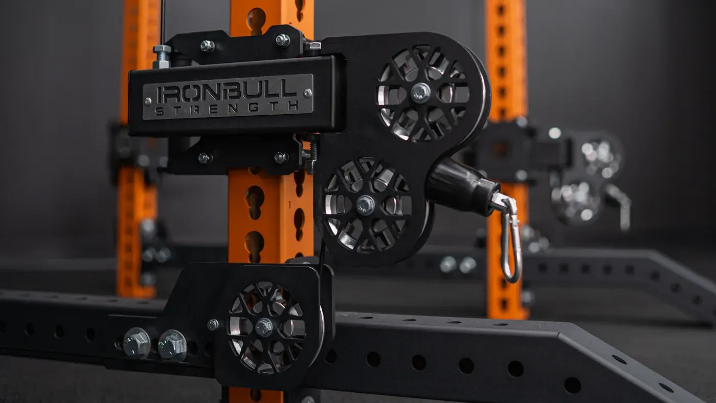 Close-up of a weightlifting machine with 'Iron Bull Strength' branding on an orange and black frame.