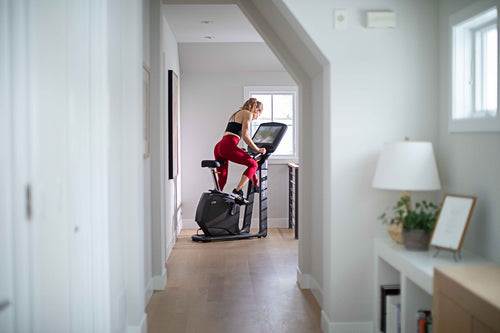 Woman exercising on a Elliptical in a home setting