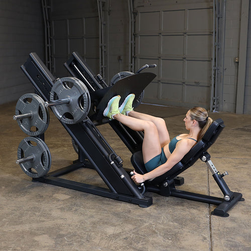 Woman using a leg press machine in a home gym setting