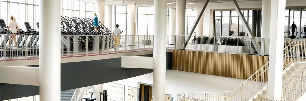 The Matrix office. Modern indoor space with high ceilings, large windows, and a staircase.