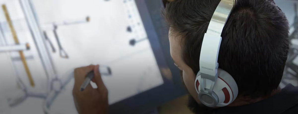 Person wearing headphones interacting with a digital drawing tablet