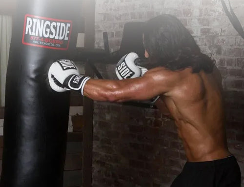 Person wearing boxing gloves and punching a punching bag with 'Ringside' branding.