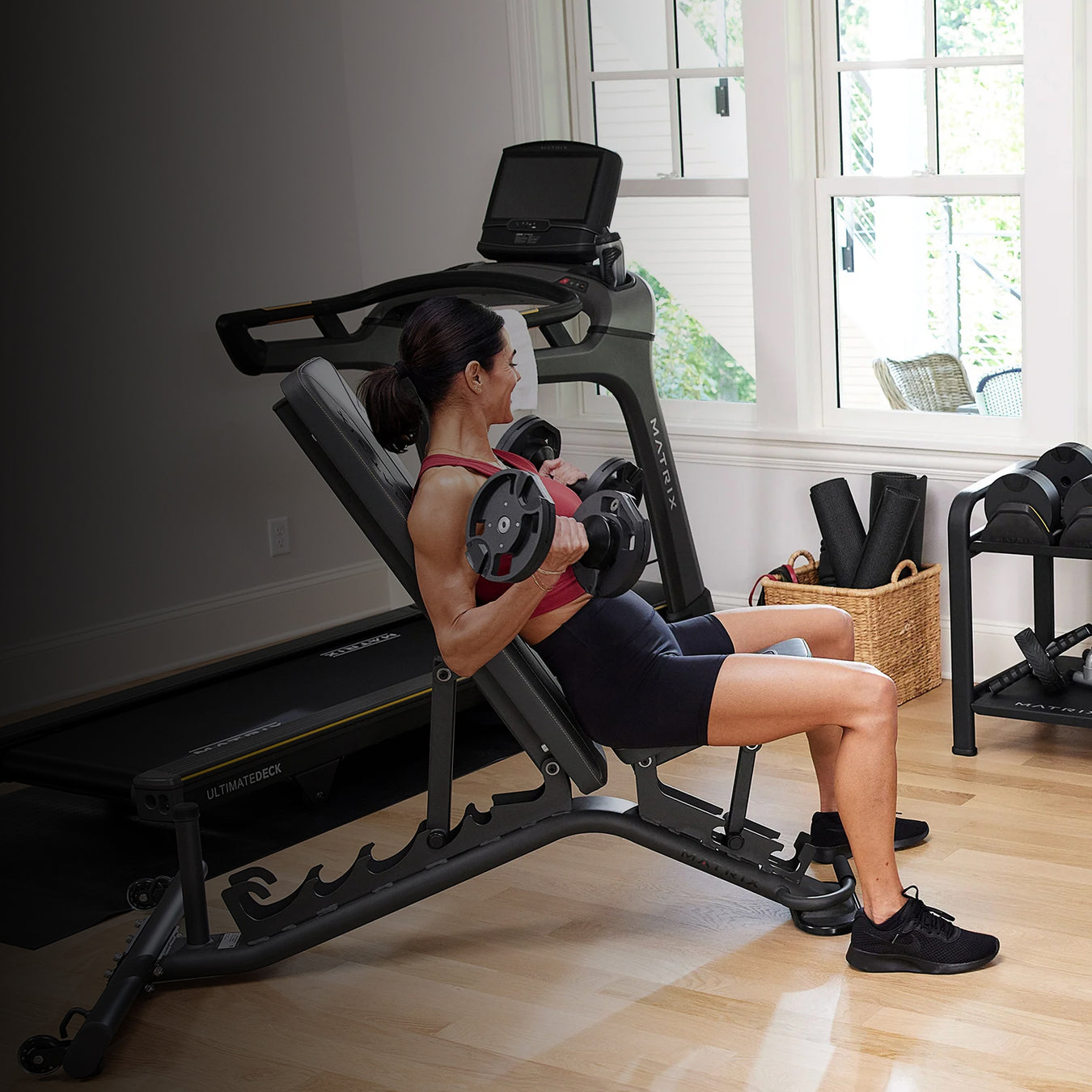 Woman exercising on a weight machine in a home gym.