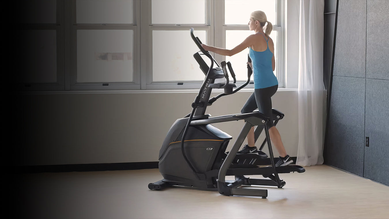 Woman exercising on a Matrix elliptical machine in a home setting