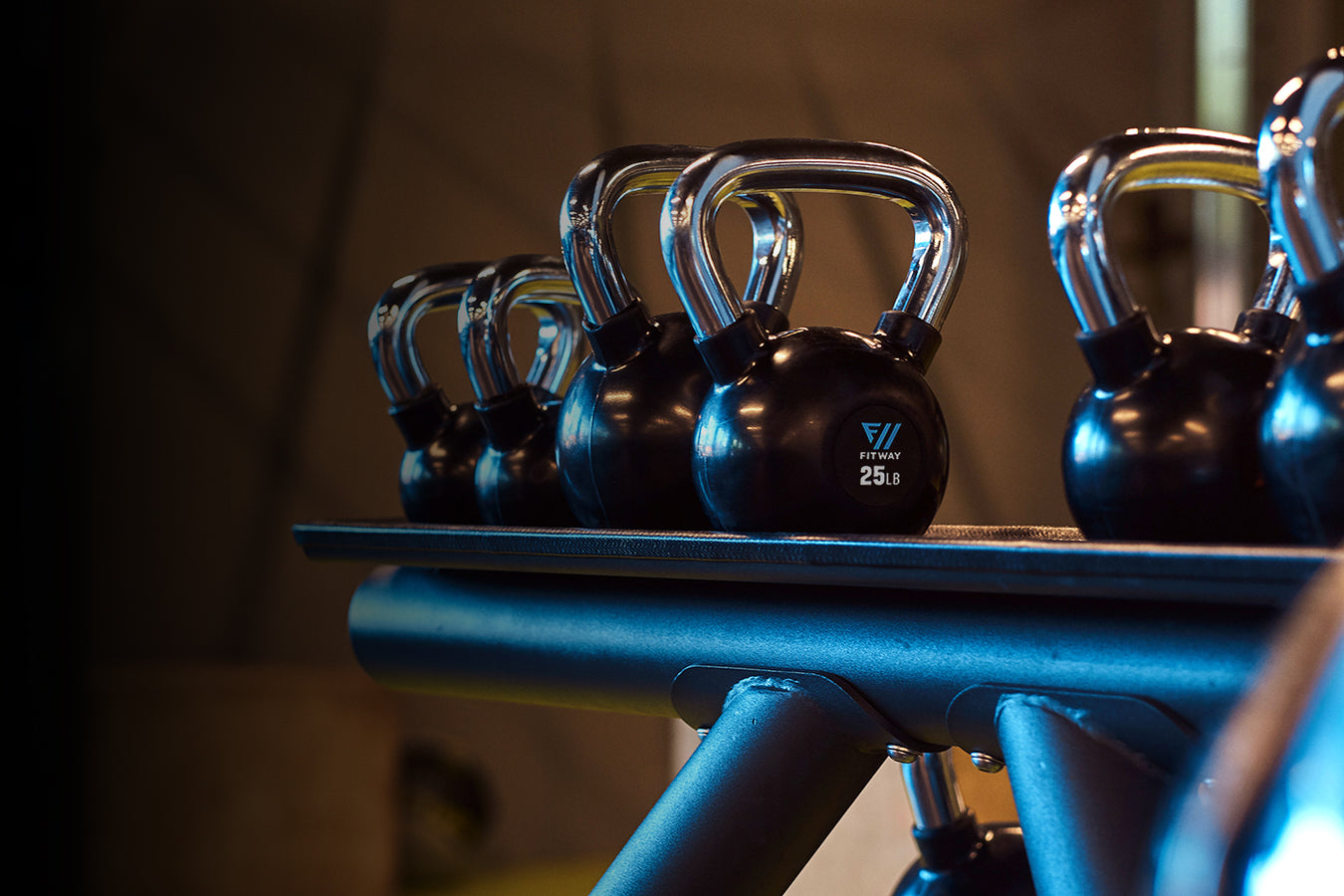 Row of Ftiway kettlebells on a rack with a blurred background