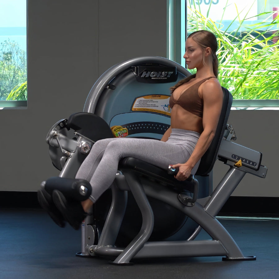 Woman exercising on a leg press machine in a gym setting