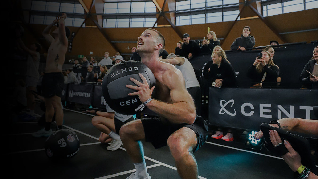 Athlete holding a basketball with 'CENTR' branding in an indoor sports setting.