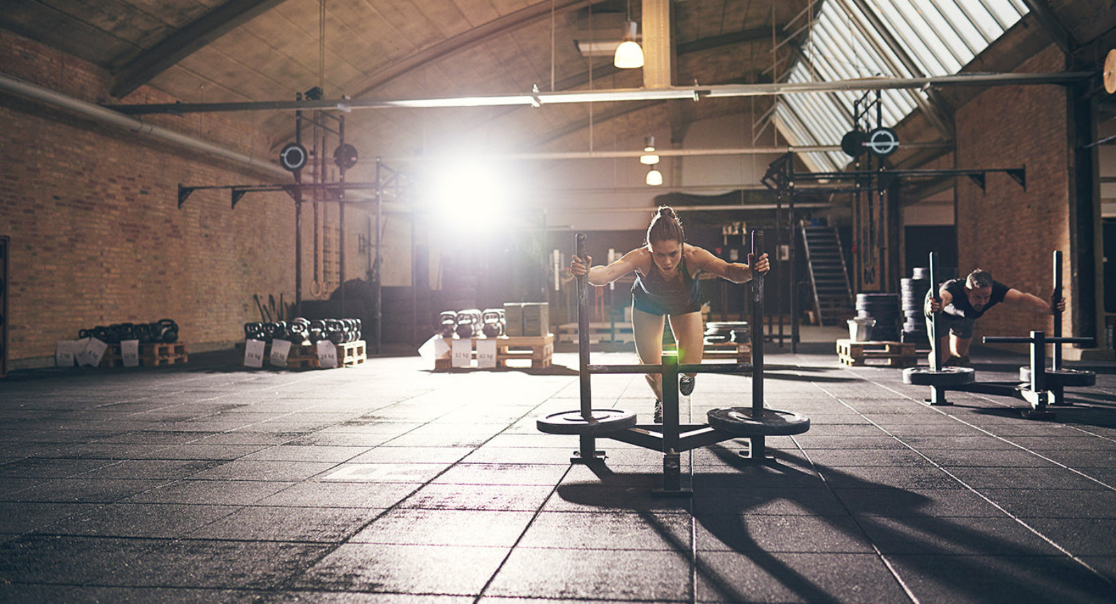 Person exercising in a gym with wooden floors and brick walls