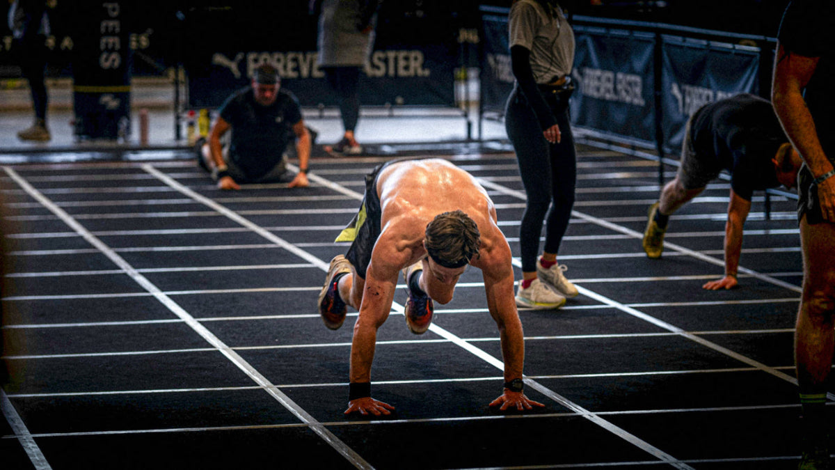 Person in a starting position on a track with others in the background