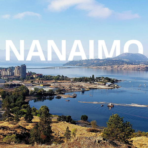 Cityscape of Nanaimo with a body of water and mountains in the background