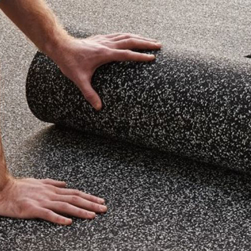 Person rolling out a roll of black textured carpet