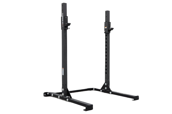 Two black low squat racks with textured powder coat paint, standing upright in a gray area, presumably a warehouse setting.